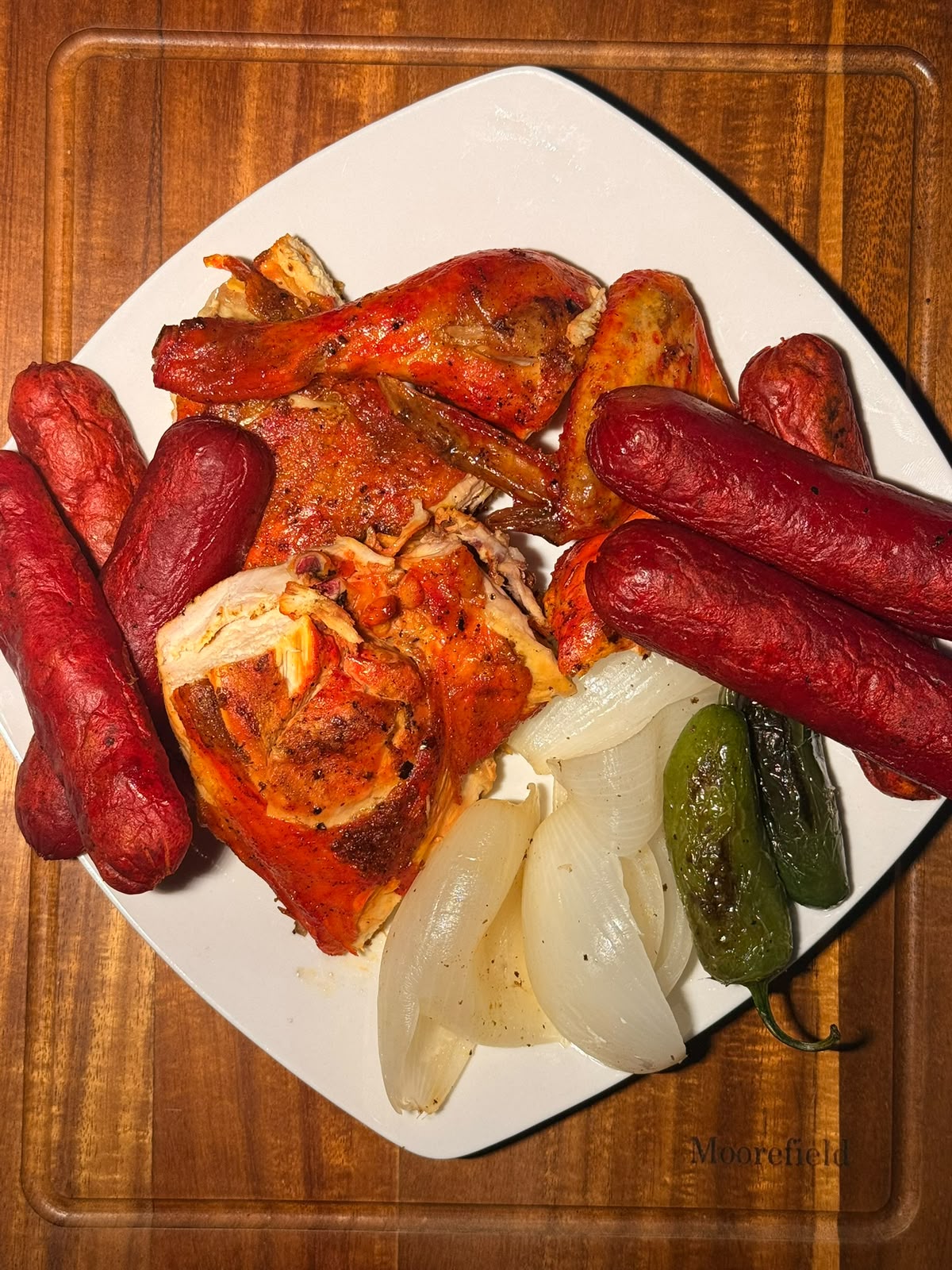Medio pollo asado dorado con cebolla asada, chiles y limones