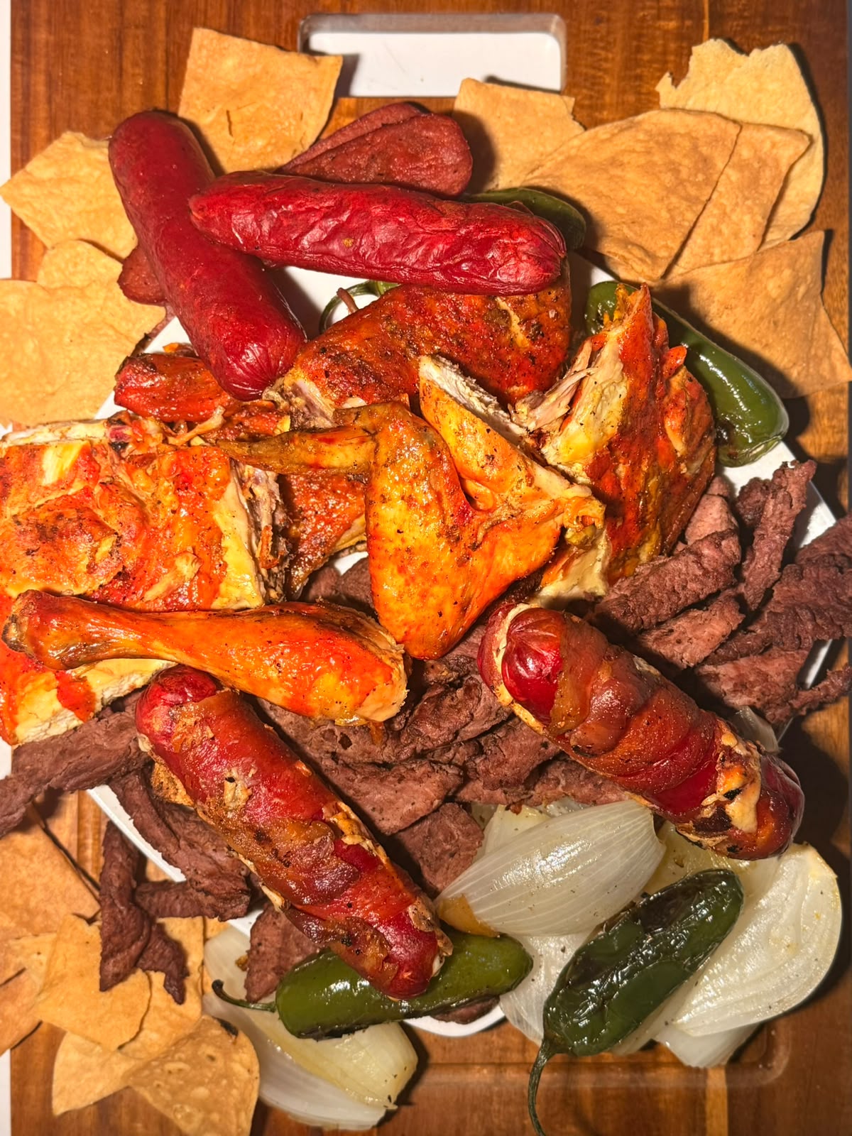Pollo asado dorado sobre la parrilla con carbón encendido y chispas