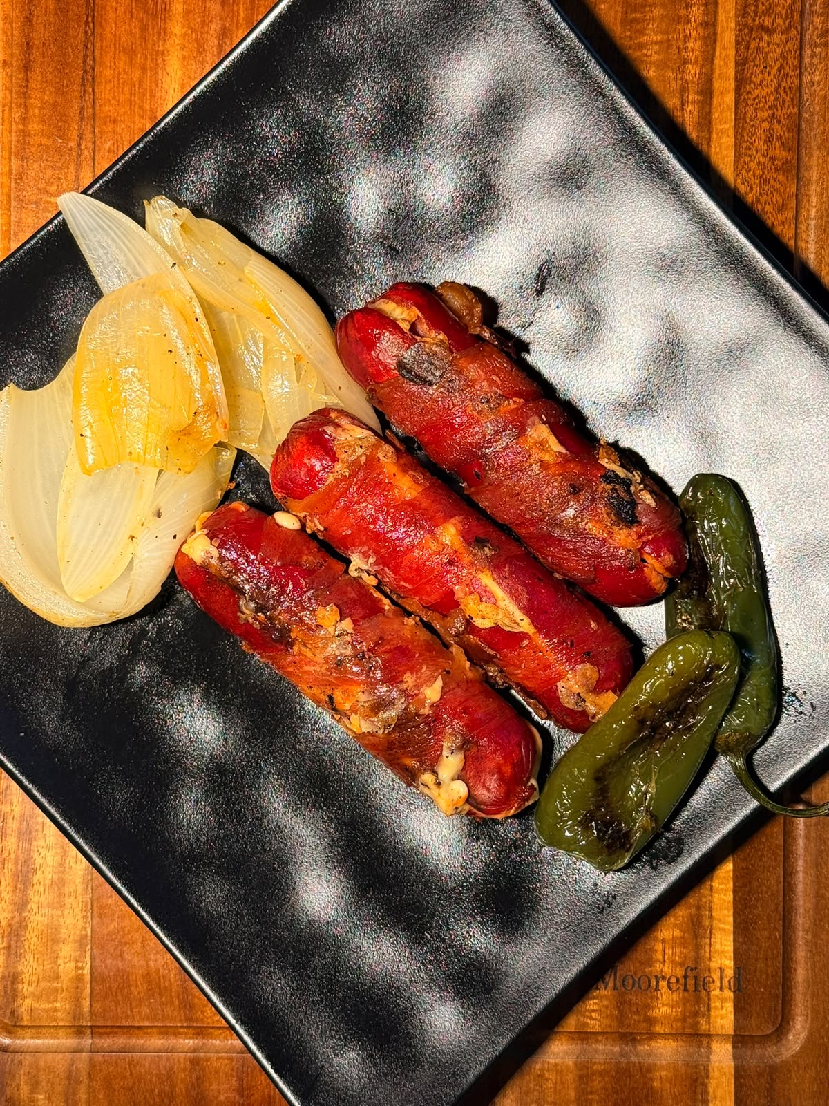 Salchichas asadas con cebolla asada y chiles toreados