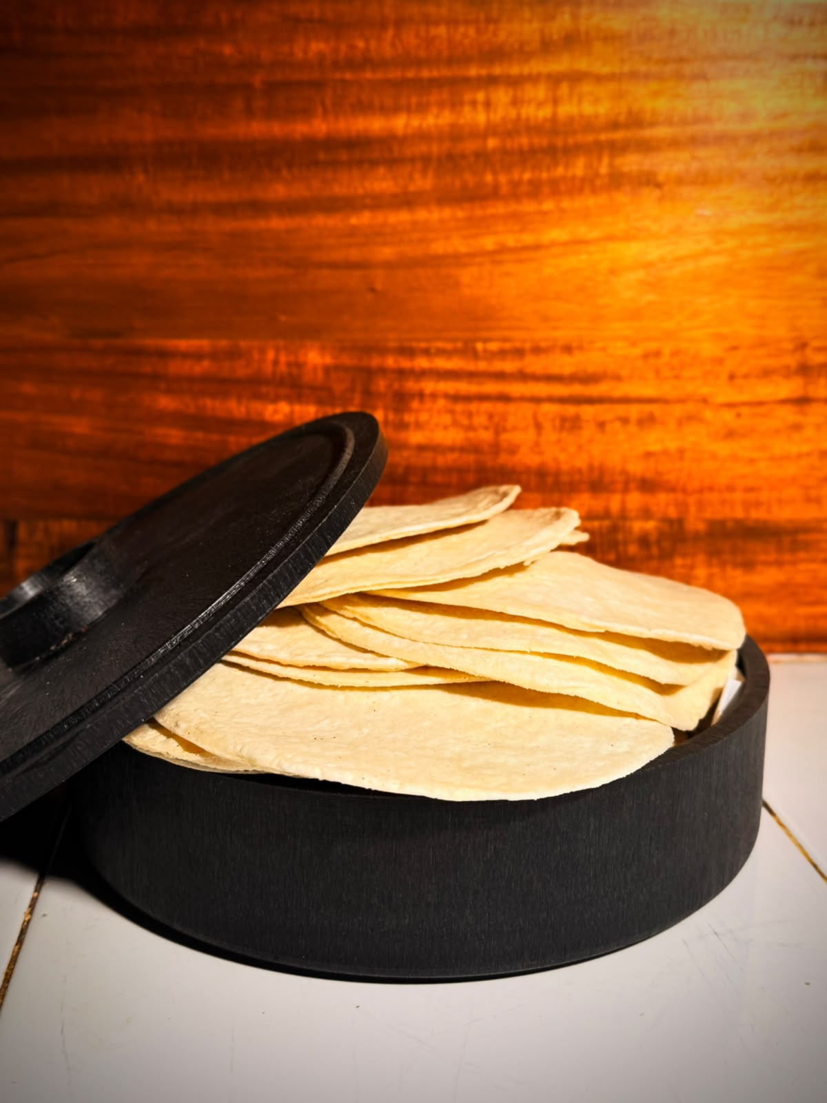 Tortillas de maíz recién hechas en tortillero negro